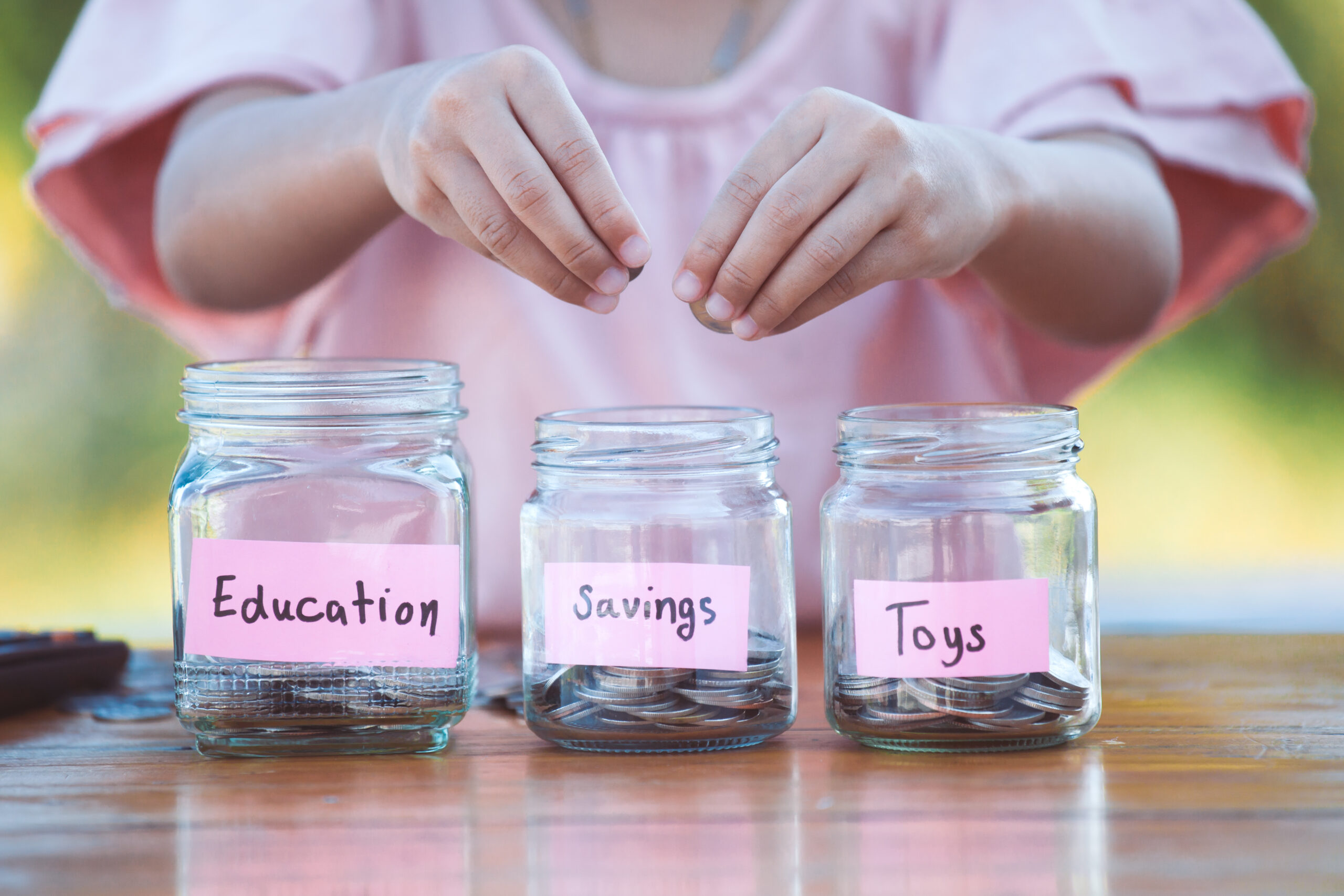 Cute,Asian,Little,Child,Girl,Putting,Coin,Into,Glass,Bottle